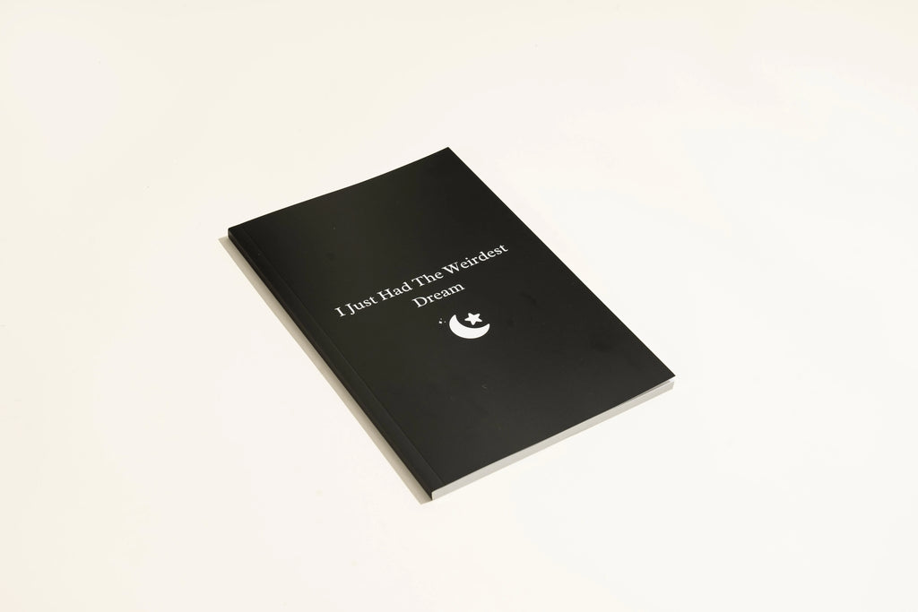 Black cover Dream Journal notebook with Business Simplicity design, open to show dot grid interior pages.