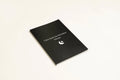 Black cover Dream Journal notebook with Business Simplicity design, open to show dot grid interior pages.