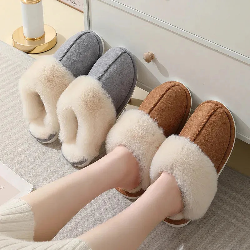 Women's plush winter slippers in pink with a round toe, flat heel, and decorative stitching.