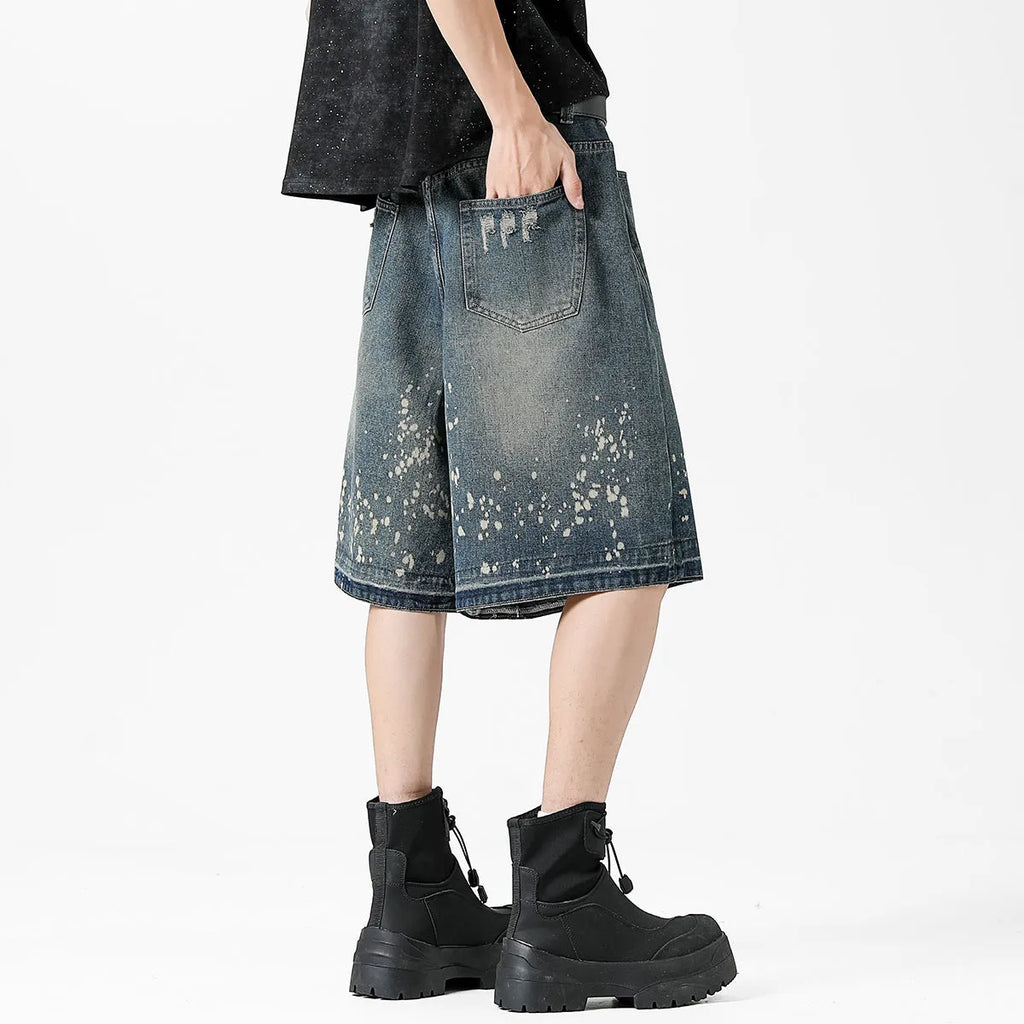 Men's retro blue washed denim shorts with ripped and splash ink distressing detail on straight-leg cut
