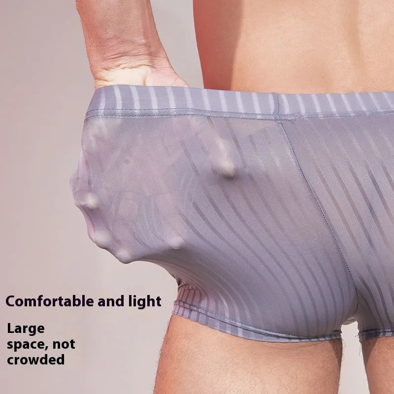 Men's black and white striped low-rise nylon briefs on a flat surface