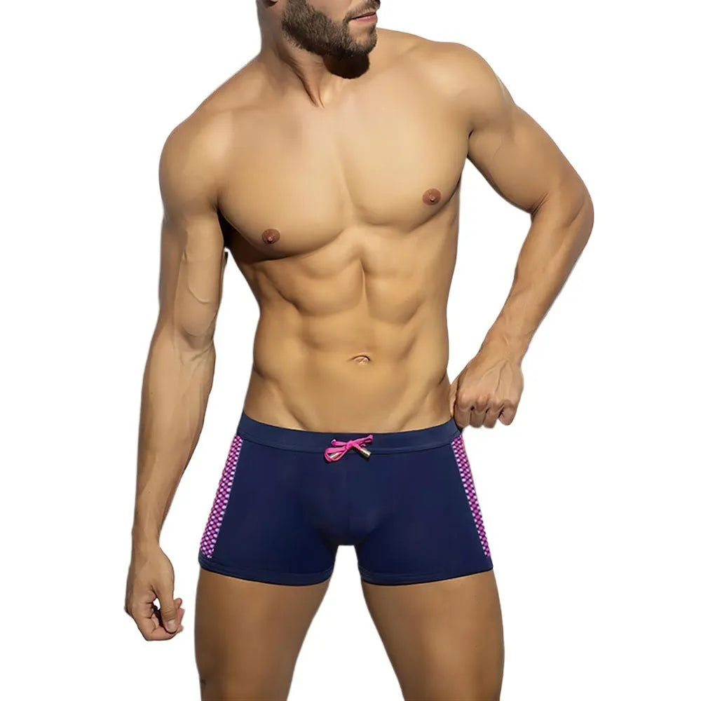 Men's yellow polka dot print swimming boxers with a black ribbon detail on a mannequin.