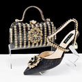 Women's black high heel ankle-strap sandals with floral buckle and chain detail next to matching clutch bag