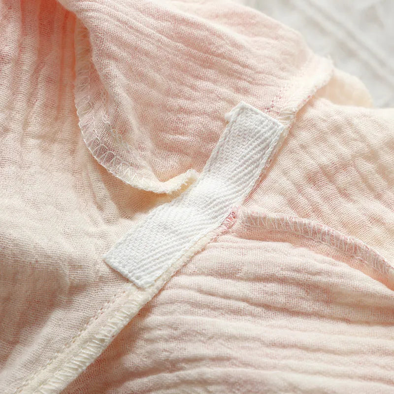 Women's cotton gauze loungewear set showing long sleeve shirt and matching trousers with lace-up detail in pastel colour