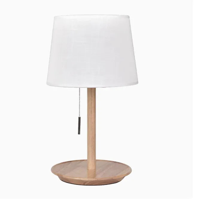 Walnut coloured solid wood desk lamp with a white cloth lampshade and a black cable switch.