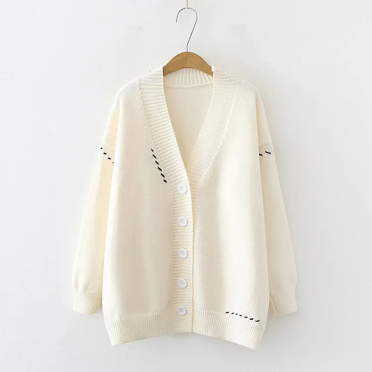 Women's loose fit knitted cardigan top coat in black or white colour with long sleeves.