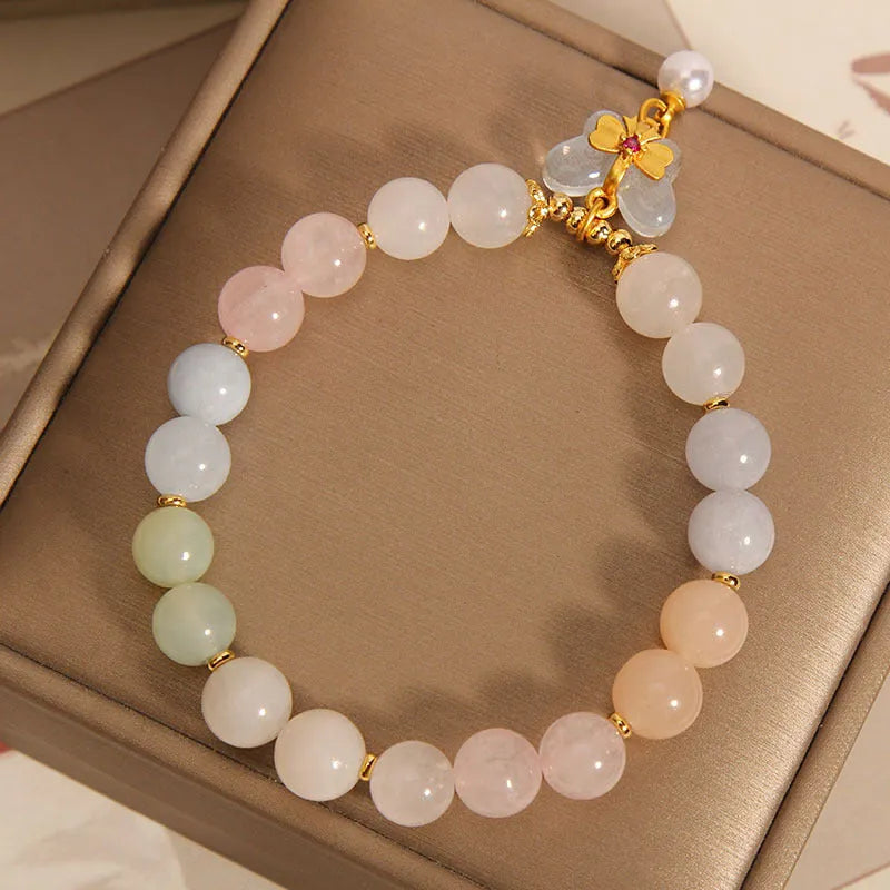 Women's adjustable crystal bracelet with a colourful morganite butterfly pendant on a white background.