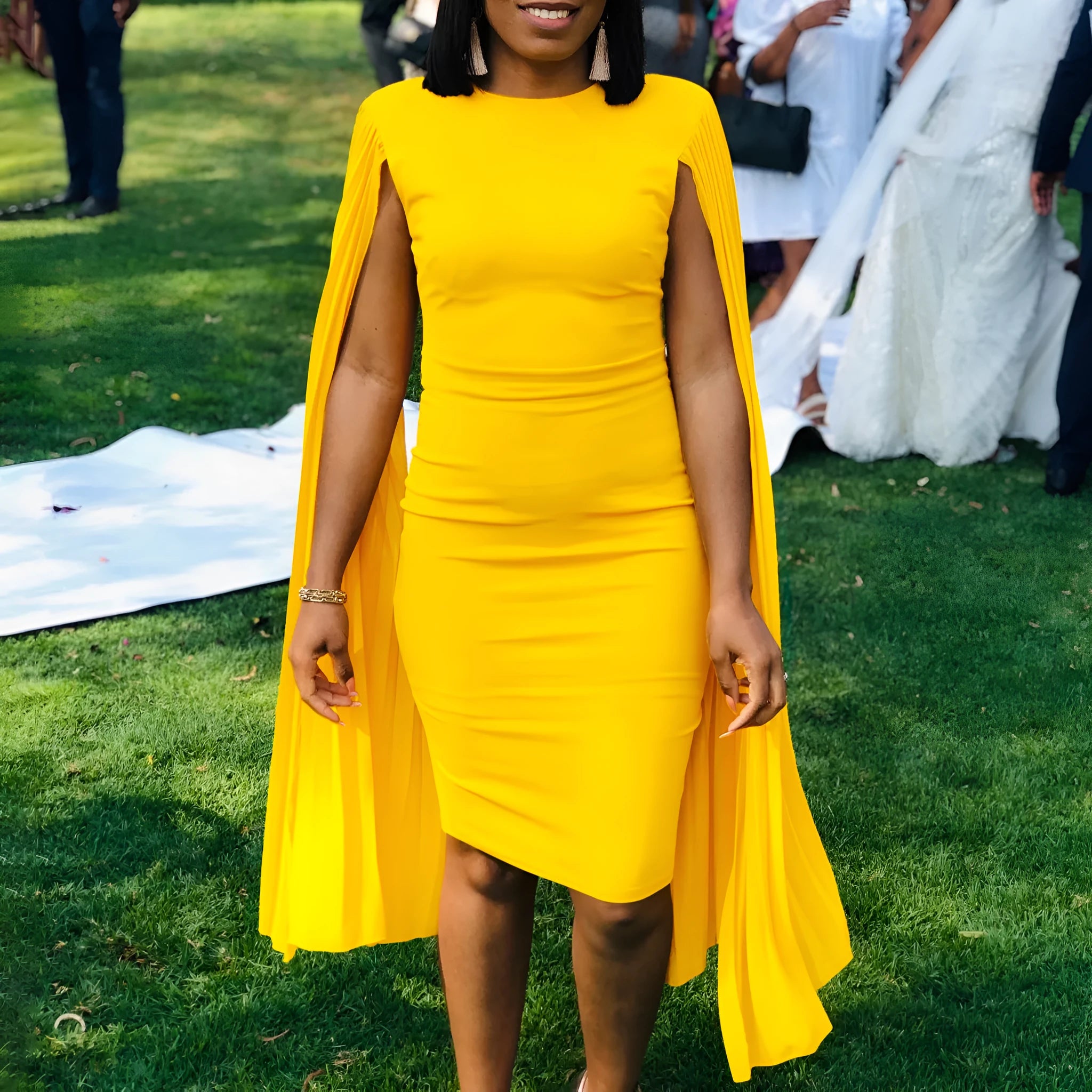 Yellow long sleeve evening gown with high waist and pleated shawl detail on a mannequin.