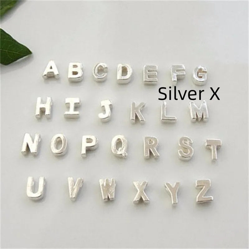 Gold heart shaped alloy pendant with initial letter on white background
