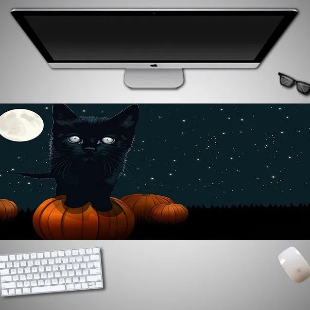 Oversized Halloween-themed gaming mouse pad on a desk, showing non-slip rubber cloth base.