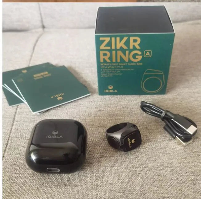 Zikr1 smart ring in black, green, rose gold, or silver on a charging case with USB cable