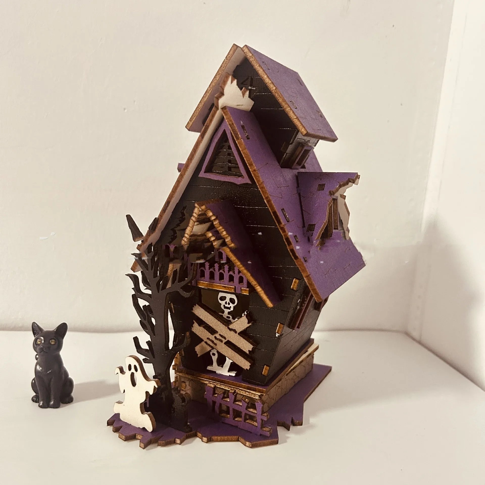 Wooden glowing haunted house Halloween table decoration with candlestick holder function.