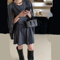 Women's black knitted two-piece set showing vest skirt with belt and long-sleeved cardigan with 3D pattern
