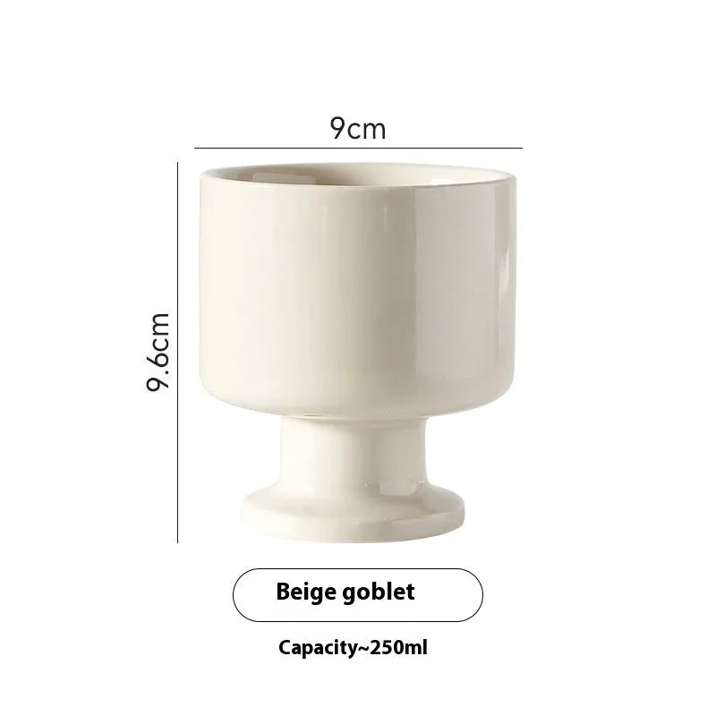 Hand-pinched irregular shaped solid colour ceramic mug on a table, showing its unique form and modern simplicity design.