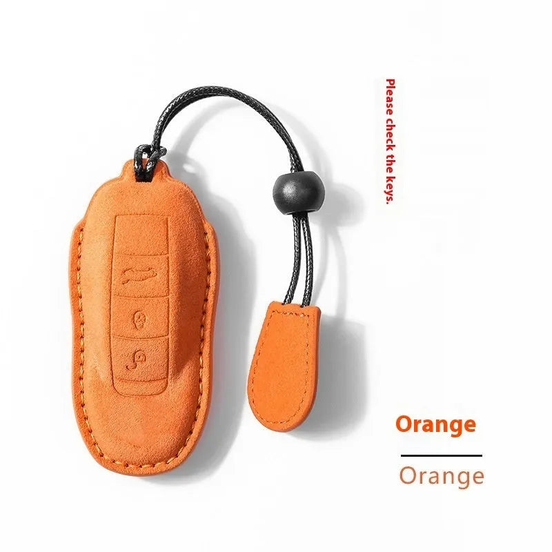 Suede car key cover protector shown in cement grey, dark green, light grey, and orange colours.