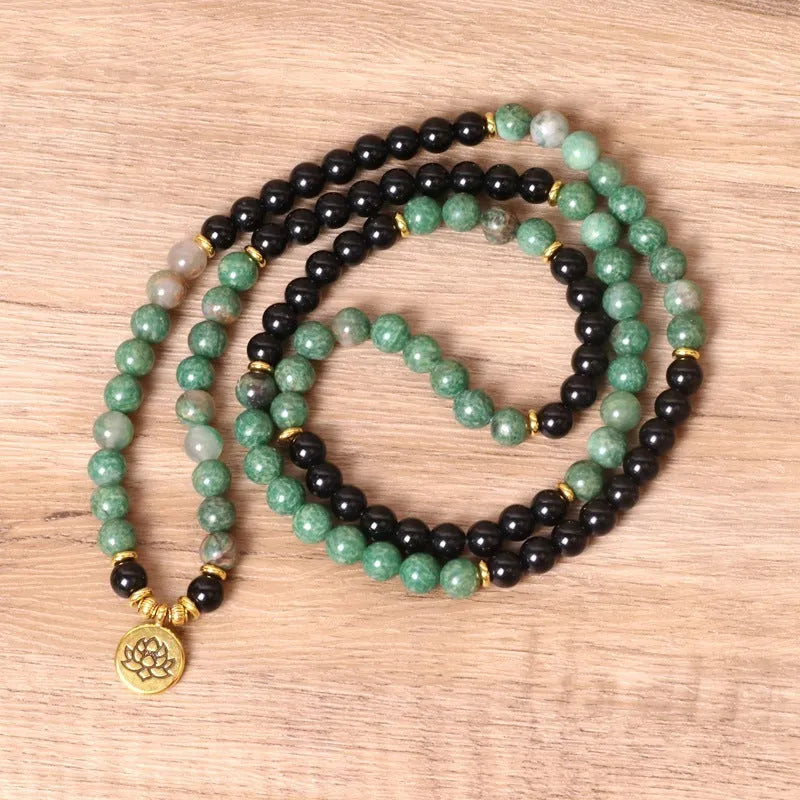 Green and black elastic beaded alloy bracelet on wrist showing natural style design