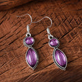 Pair of vintage geometric pendant earrings in black and purple zinc alloy with round retro design