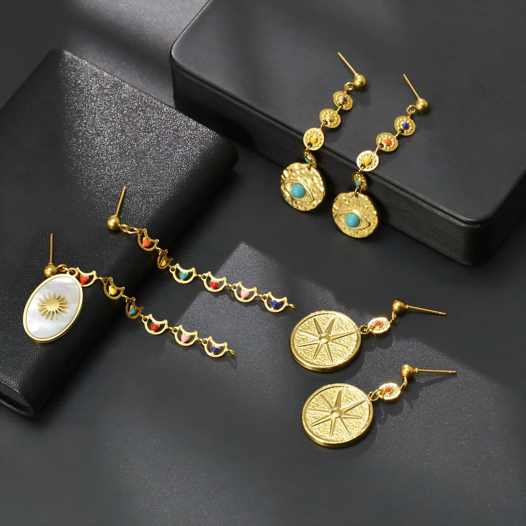 Stainless steel geometric drop earrings showing three designs: eight awn star, eye shape, and shell sun pattern