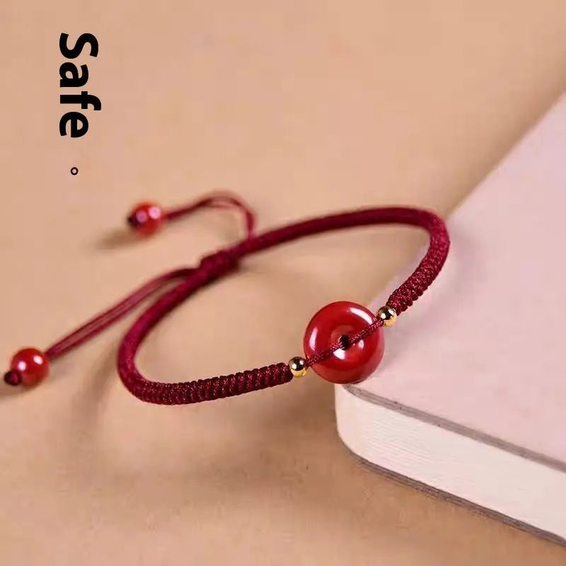 Heart-shaped cinnabar safety buckle bracelet on an adjustable rope cord.