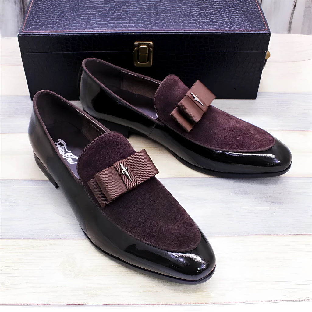 Men's black leather shoes with patent leather finish and a decorative tassel on the front.