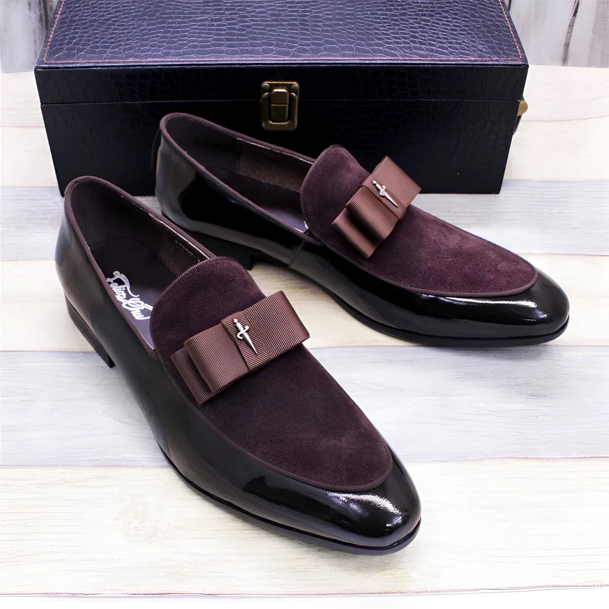 Men's black leather shoes with patent leather finish and a decorative tassel on the front.