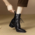 Women's black pointed-toe ankle boots with a low heel on a plain background.