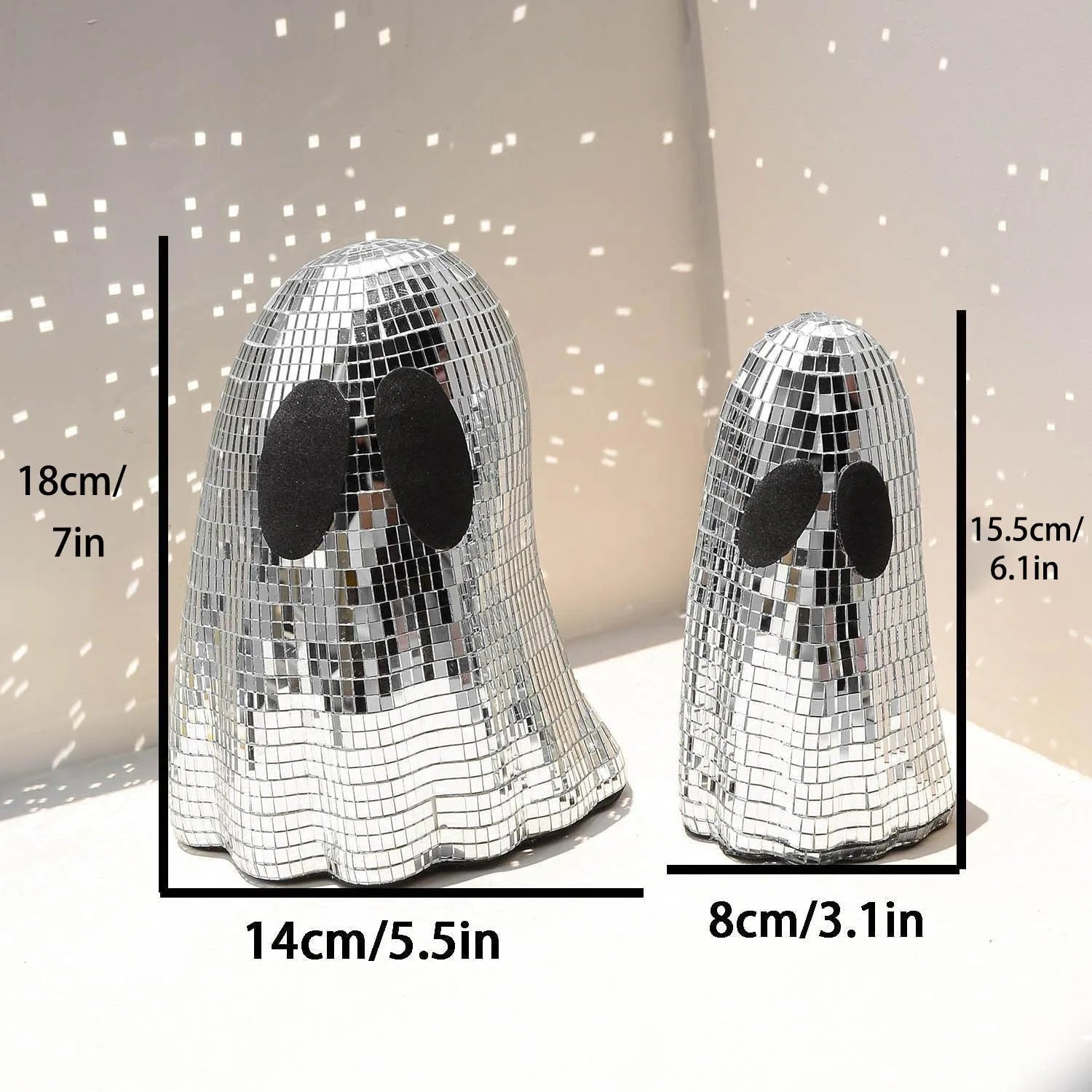 Silver glass ghost decoration with mosaic mirror patch on a desktop for Halloween.