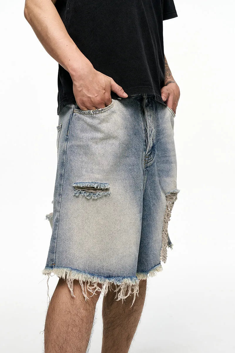 Men's light blue baggy denim shorts on a mid-waist mannequin, showing wide leg cut and zipper fly.