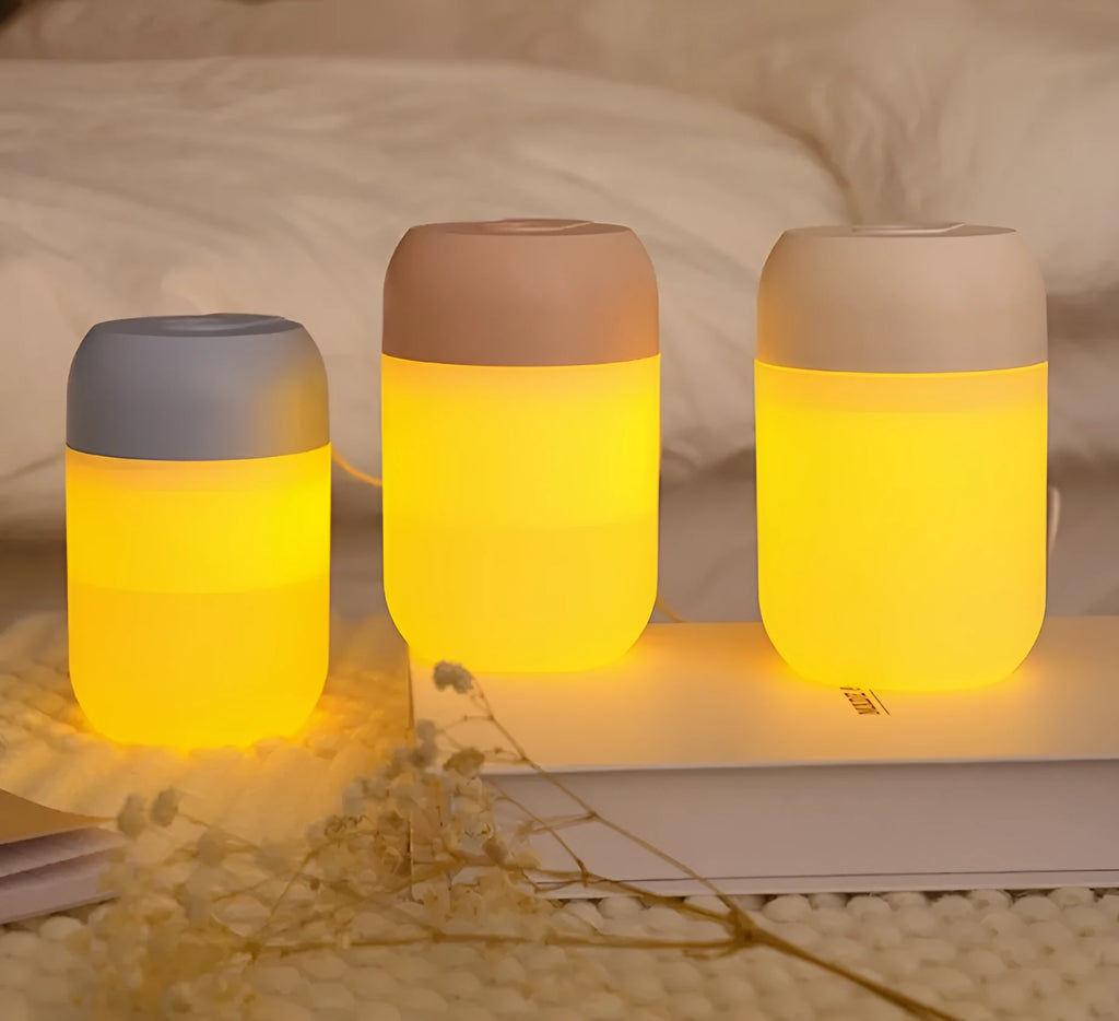 White cylindrical USB-powered mini humidifier with aromatherapy function on a wooden desk.