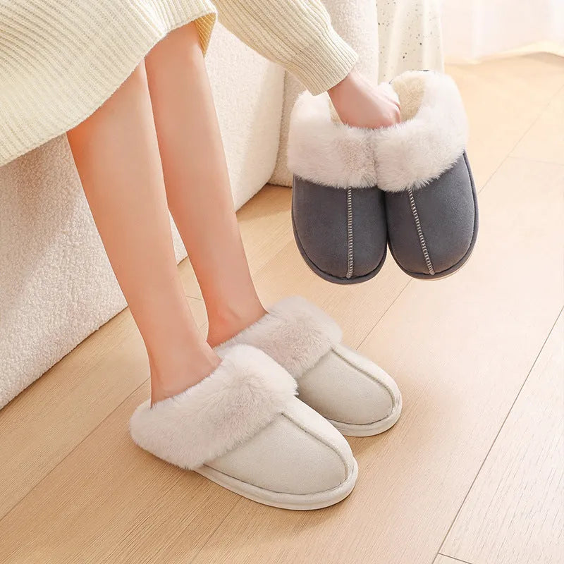 Women's plush winter slippers in pink with a round toe, flat heel, and decorative stitching.