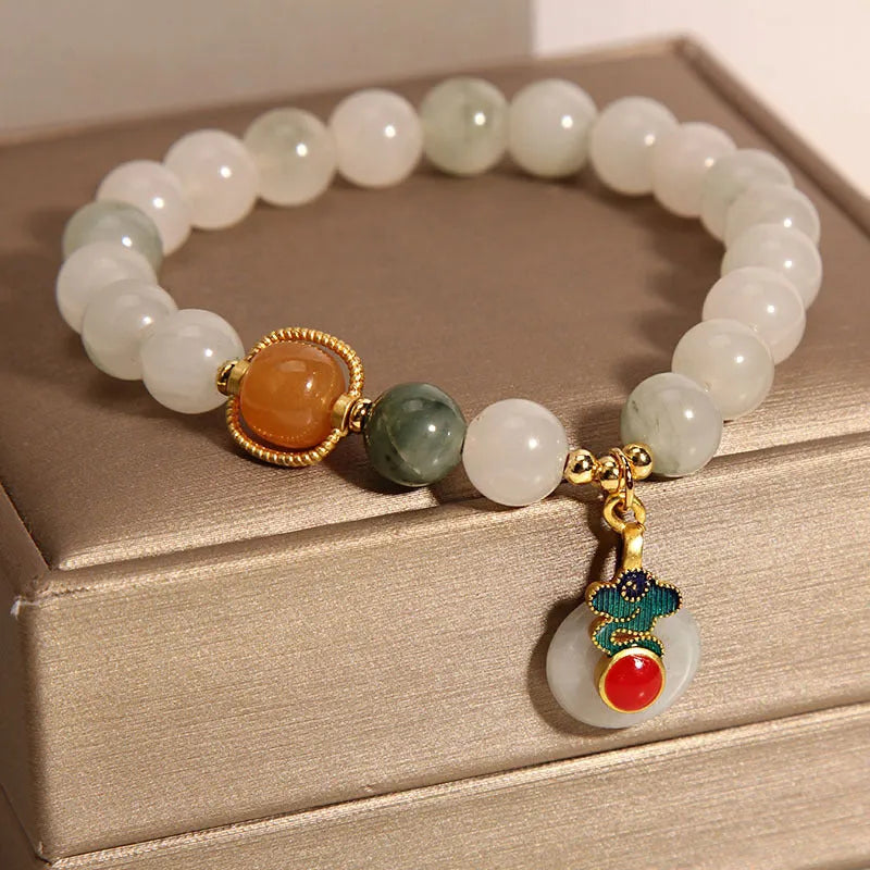 Women's ice jade crystal bracelet with pearl accents and a Xiangyun jade buckle on a white background.