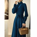 Turtleneck knitwear dress with elastic waist and loose mid-length skirt in solid colour.