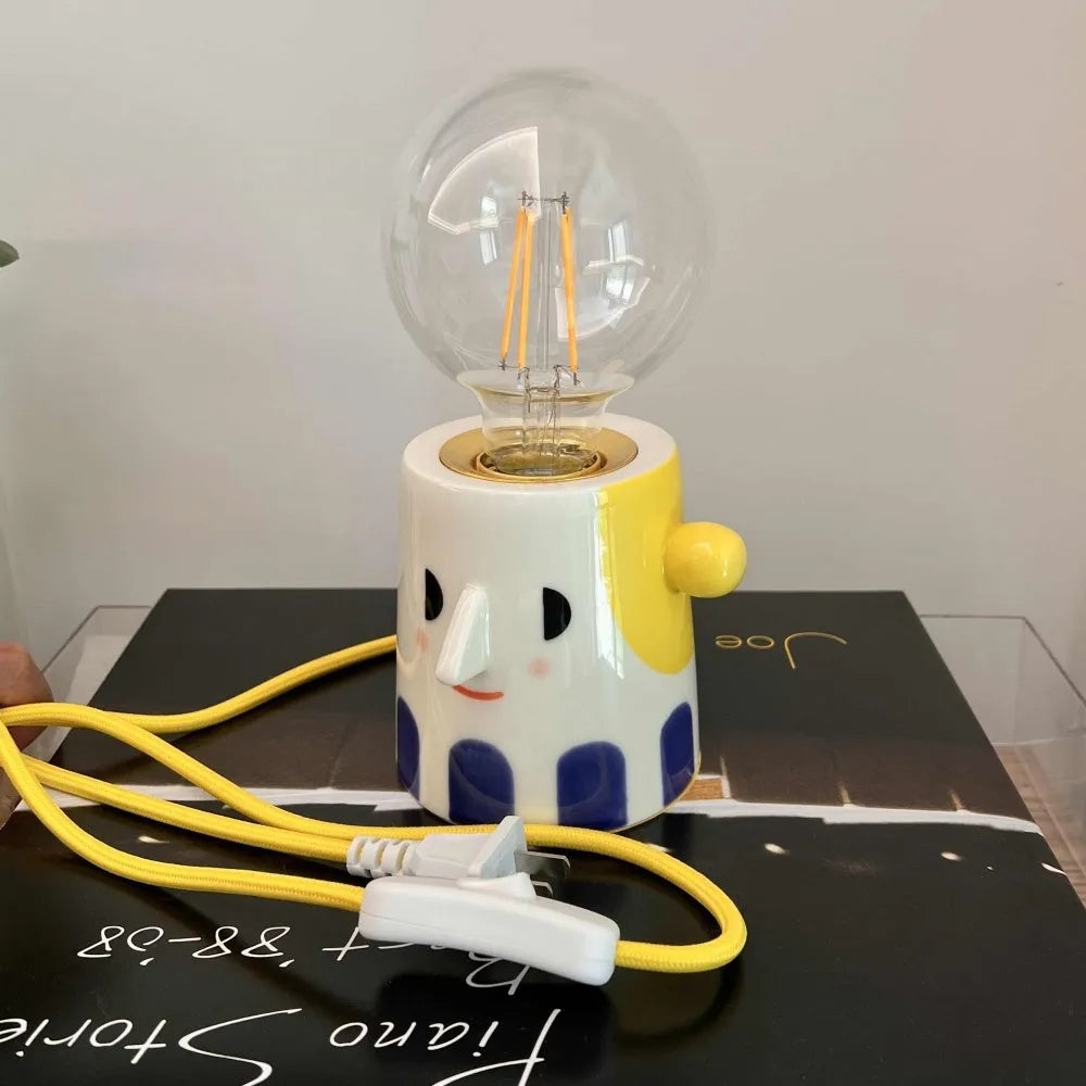 Handmade ceramic table lamp with a spherical ball headlight shape on a stand.