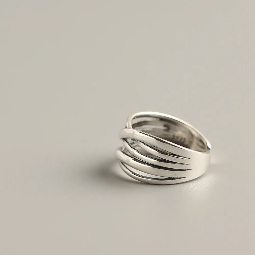 Close-up of a women's S925 sterling silver ring with a vintage weave pattern and retro silver finish.
