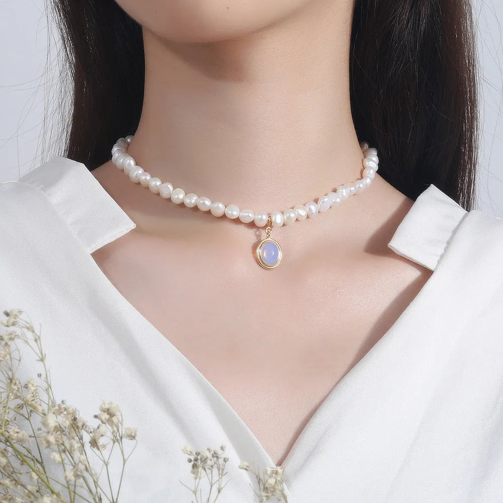 Sterling silver geometric pendant necklace with irregular pearl on adjustable chain.