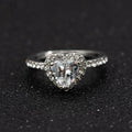 Women's heart-shaped crystal wedding ring in rose gold or silver on a white background.