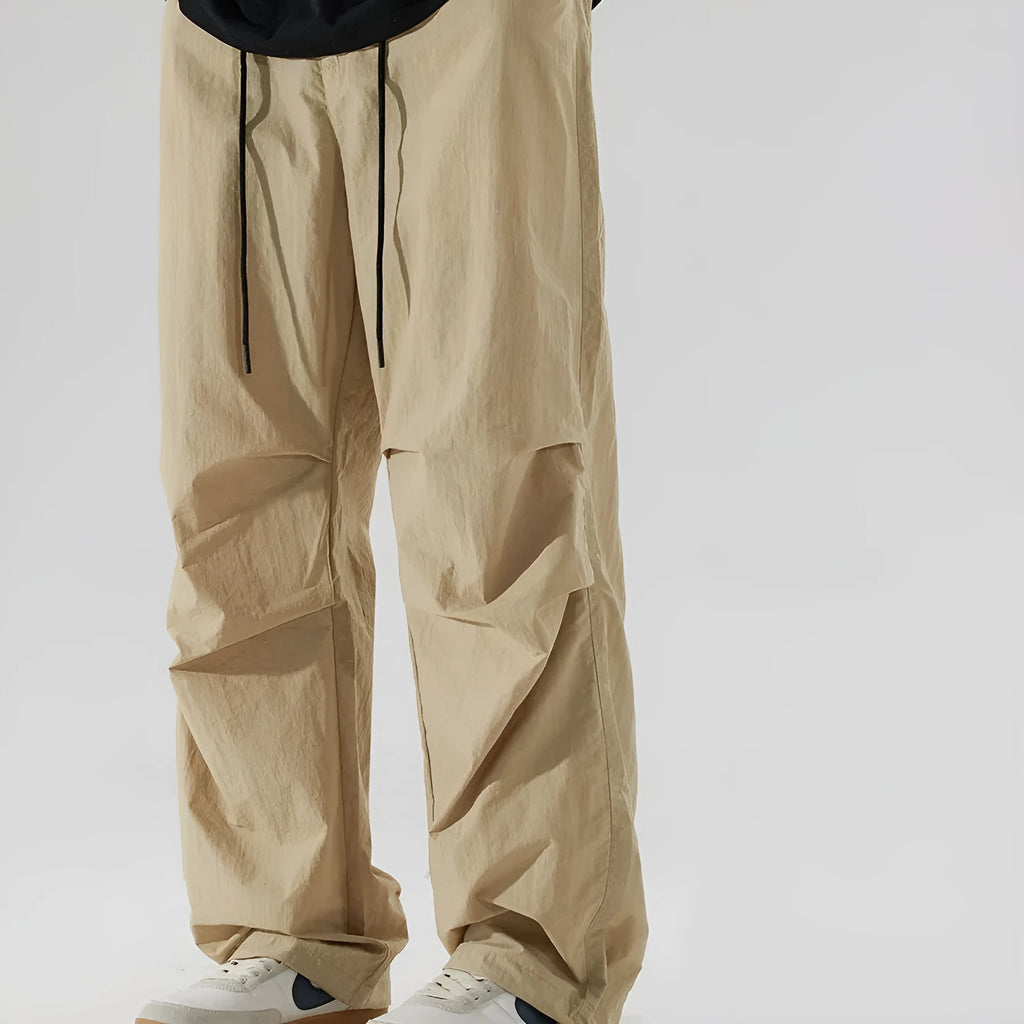 Men's straight-leg casual trousers in lightweight nylon fabric, shown in multiple colour options.