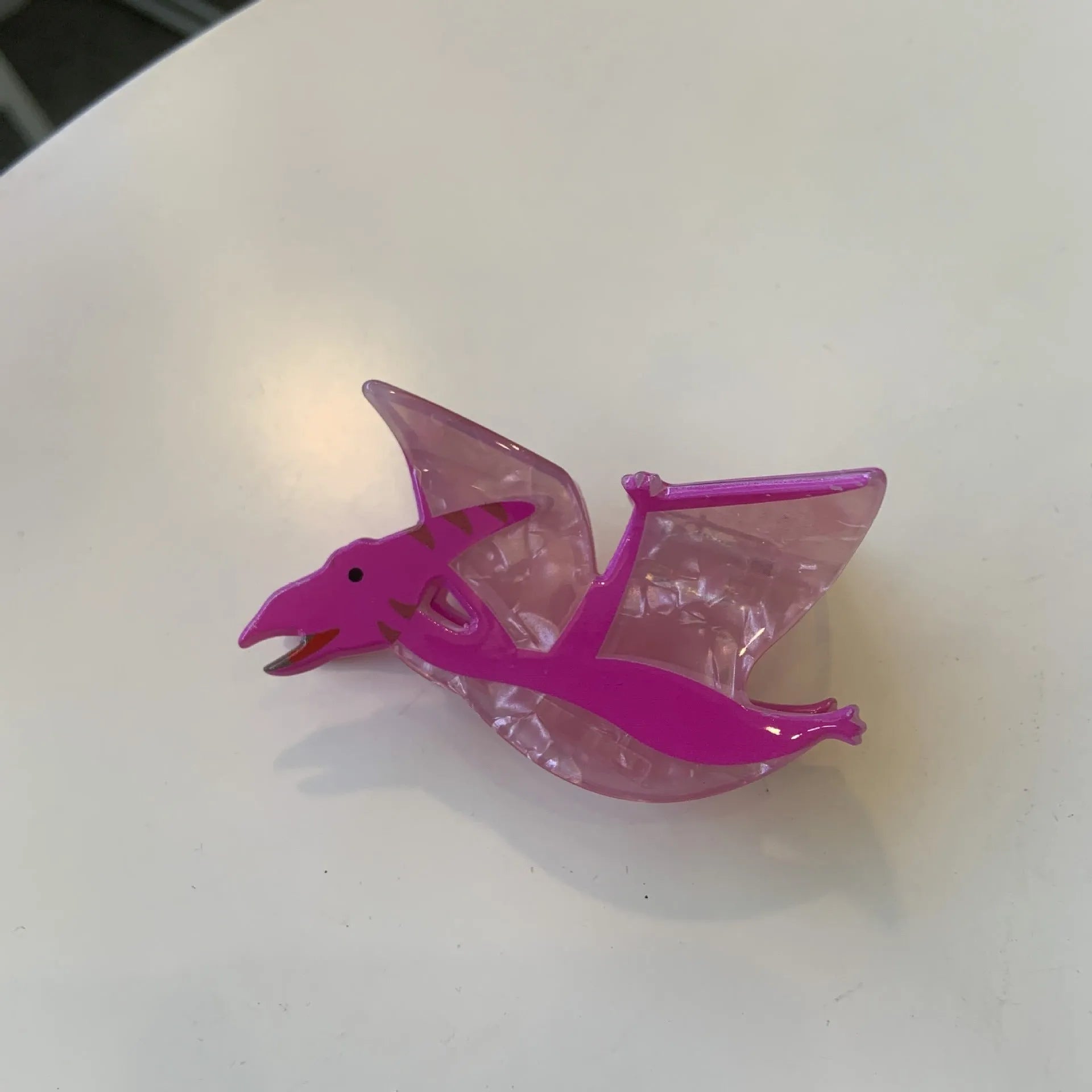 Colourful dinosaur-themed acrylic jaw hair clip showing multiple design options