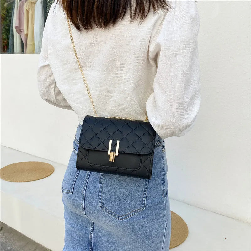 Women's diamond lattice chain crossbody bag in black with adjustable strap