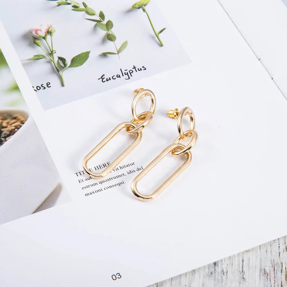 Geometric sterling silver needle hoop earrings with a line and ring design on a model.