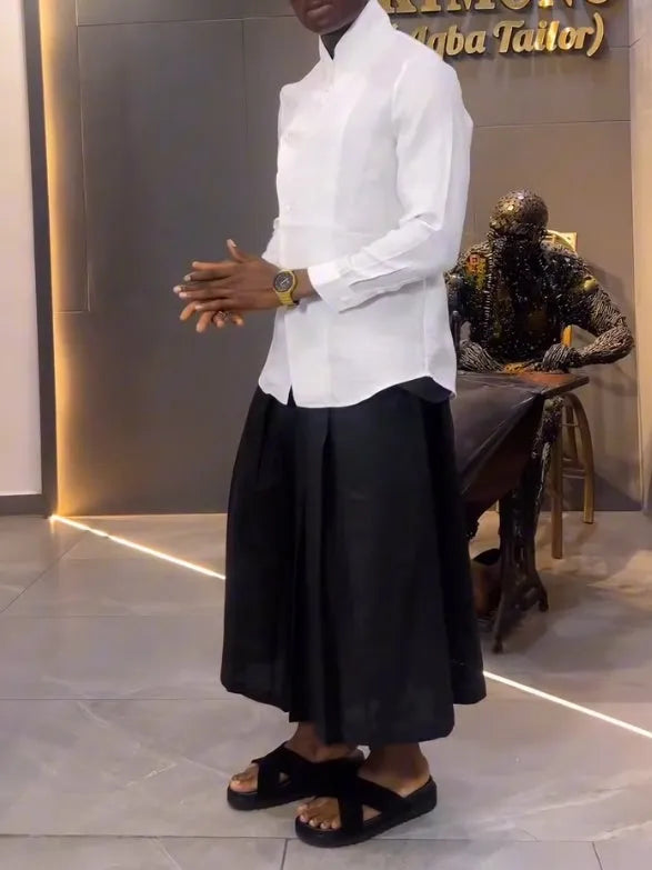 White asymmetric front long sleeve shirt and black pleated trousers co-ordinates set on a hanger