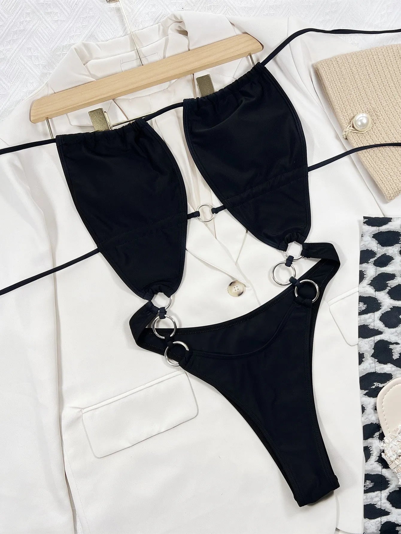 Black solid colour sleeveless one-piece swimsuit for women on a hanger.