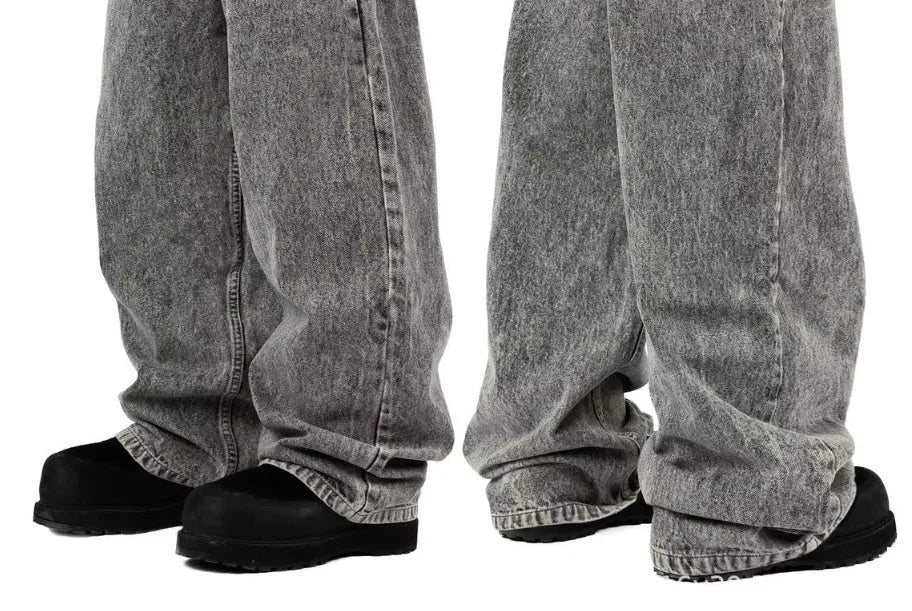 Grey loose straight-leg denim trousers on hanger showing mid-rise waist and cotton denim fabric