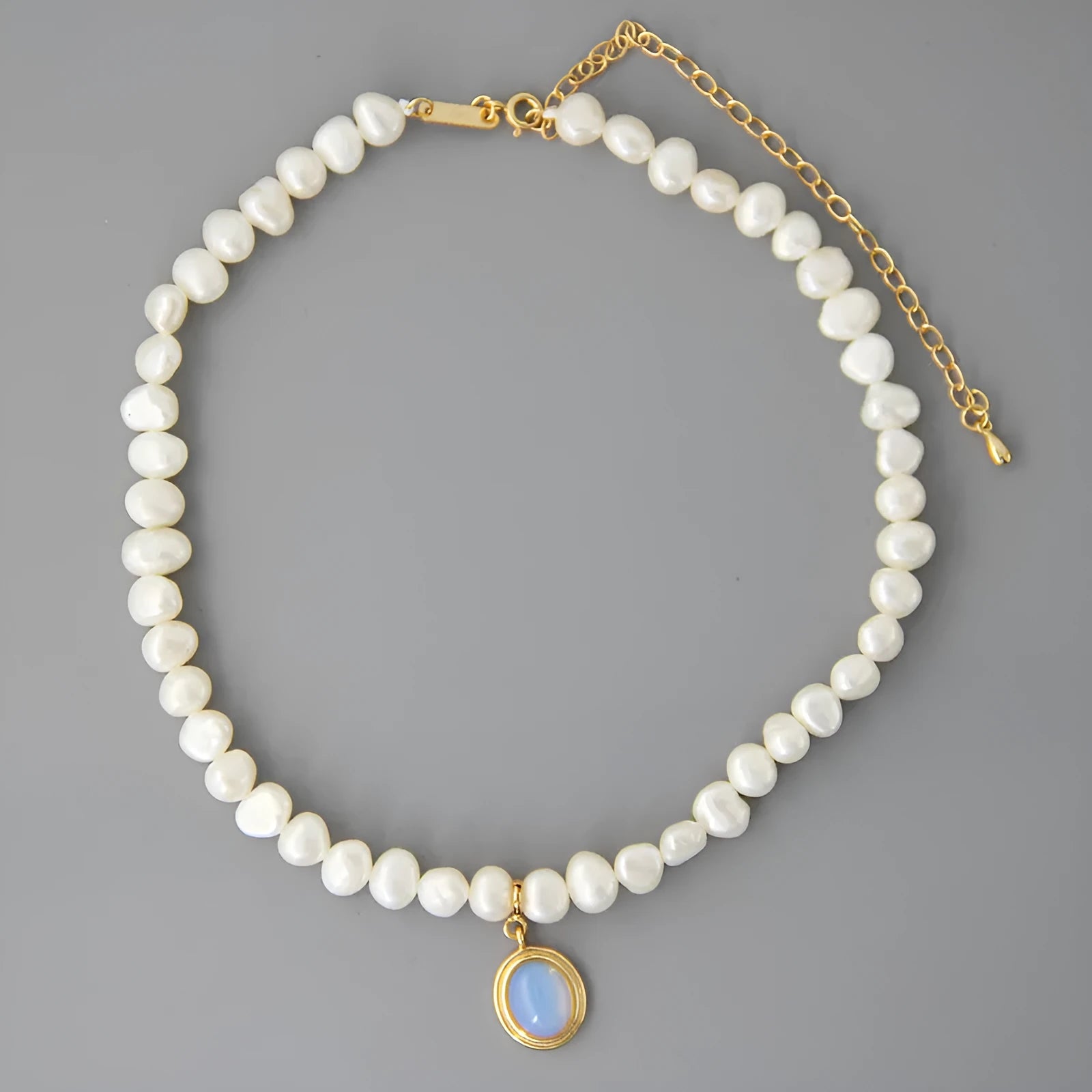 Sterling silver geometric pendant necklace with irregular pearl on adjustable chain.