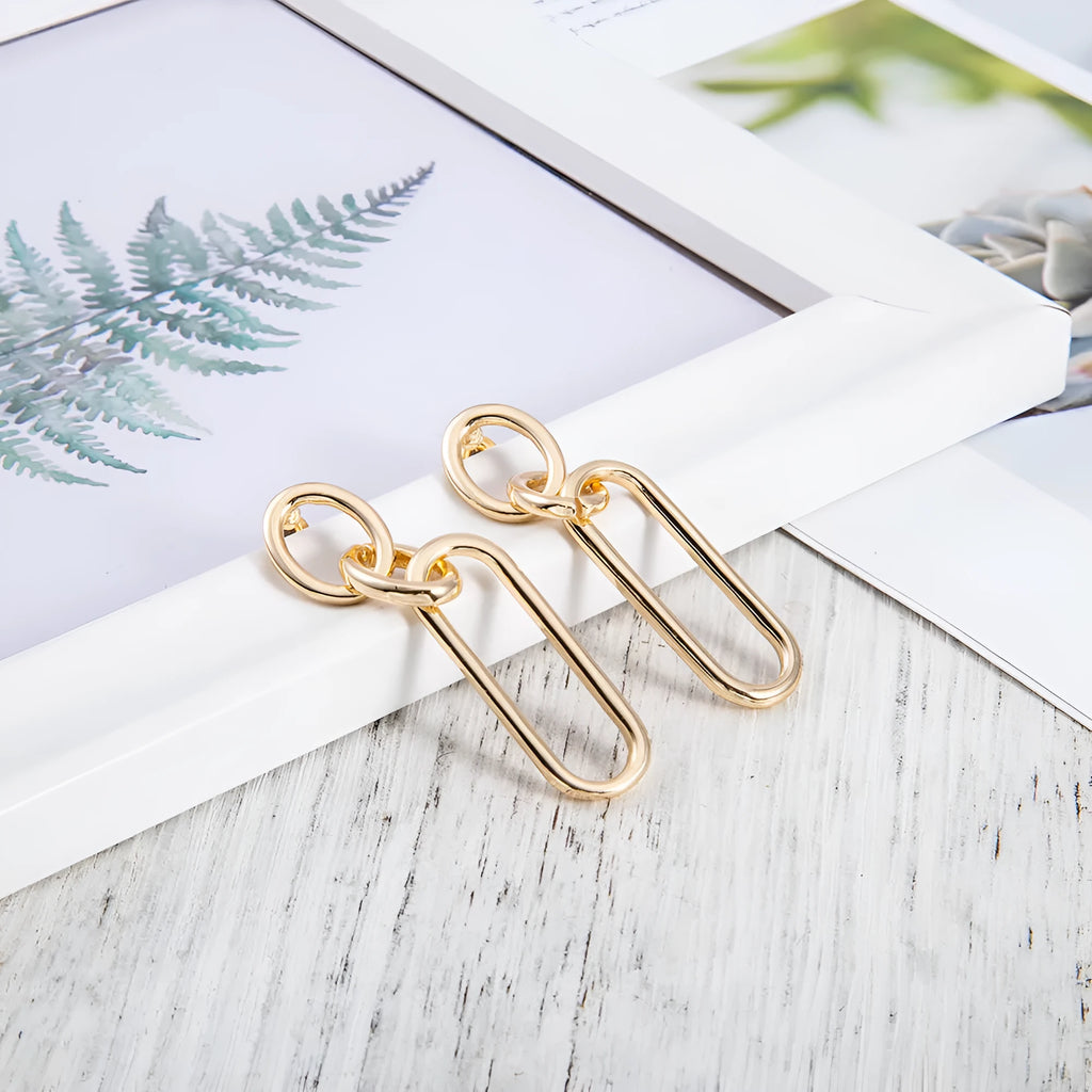 Geometric sterling silver needle hoop earrings with a line and ring design on a model.