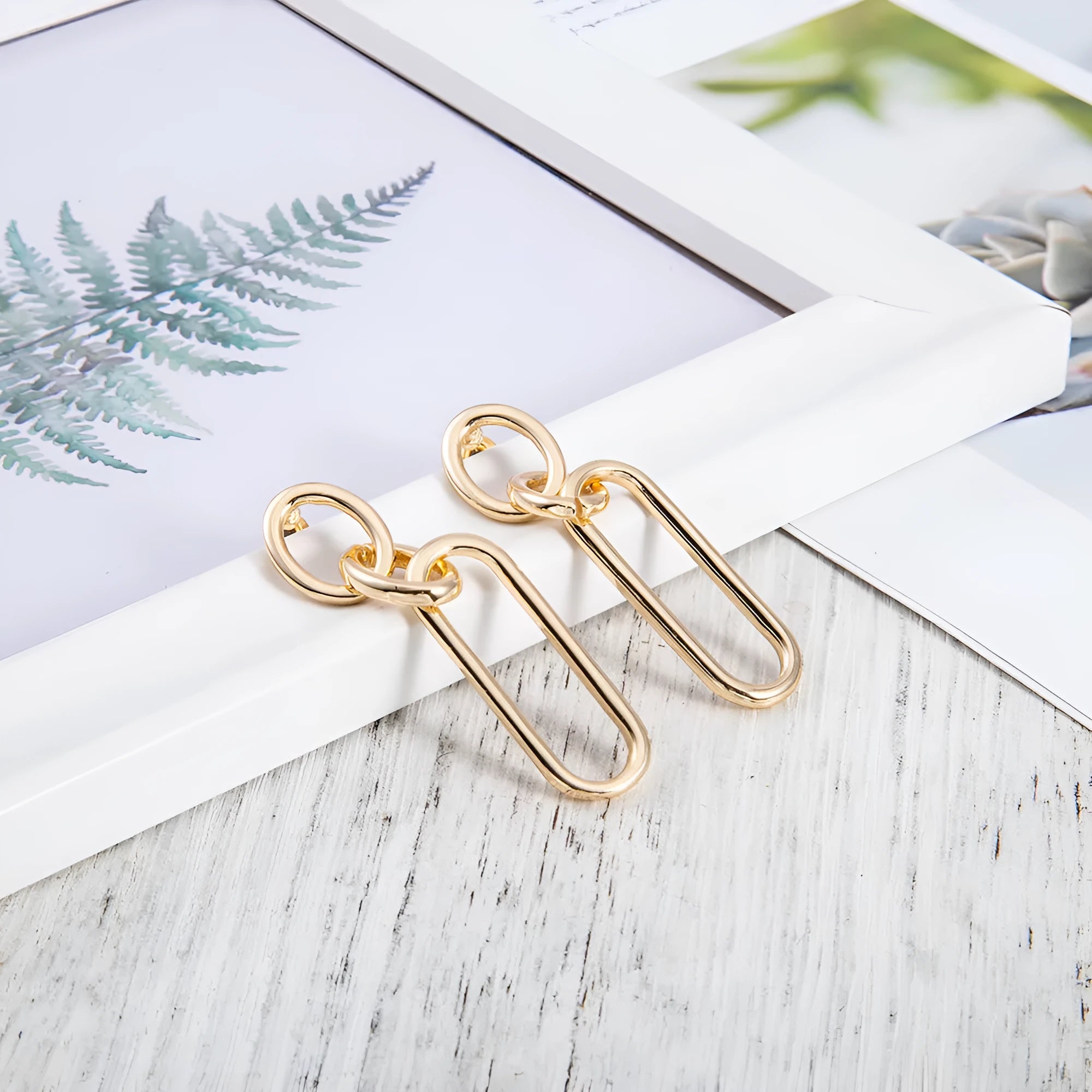 Geometric sterling silver needle hoop earrings with a line and ring design on a model.