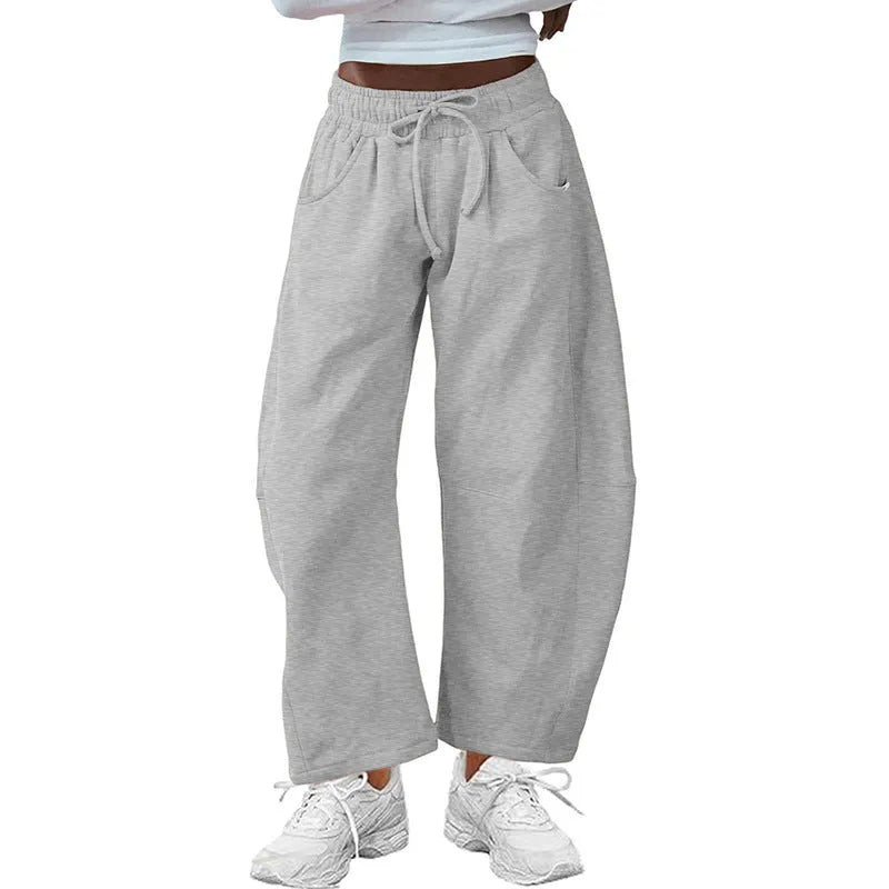 Loose cropped sweatpants with drawstring waist in apricot colour showing side pockets and street fashion styling