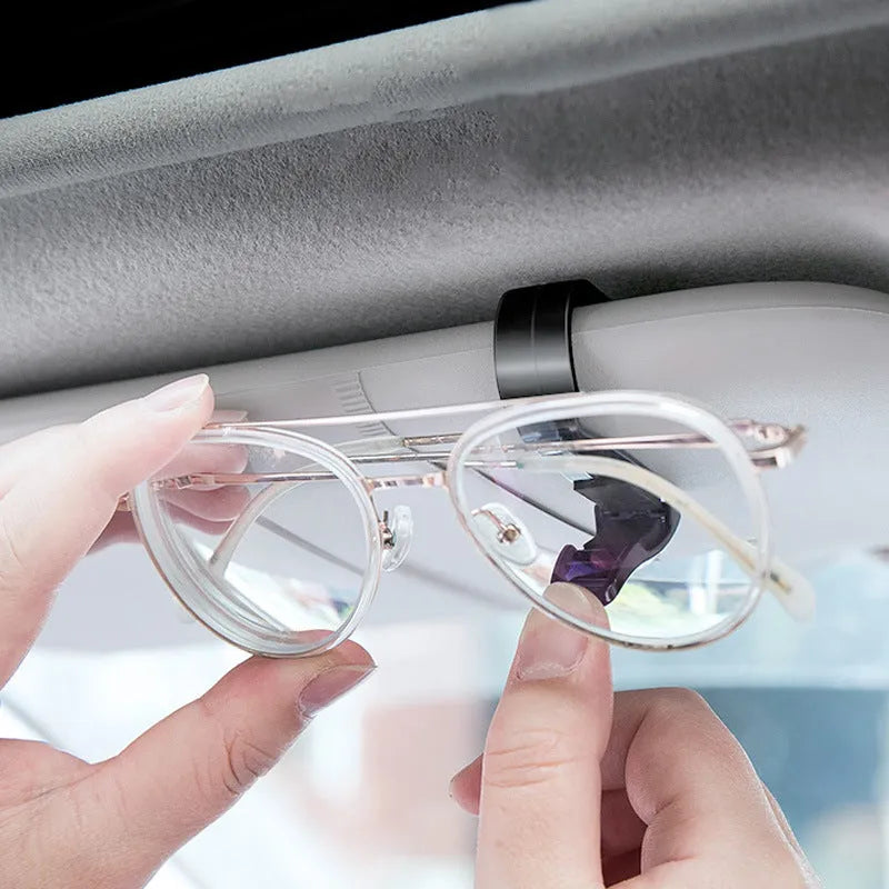 Black plastic clip for car sunshade holding sunglasses and an ID card