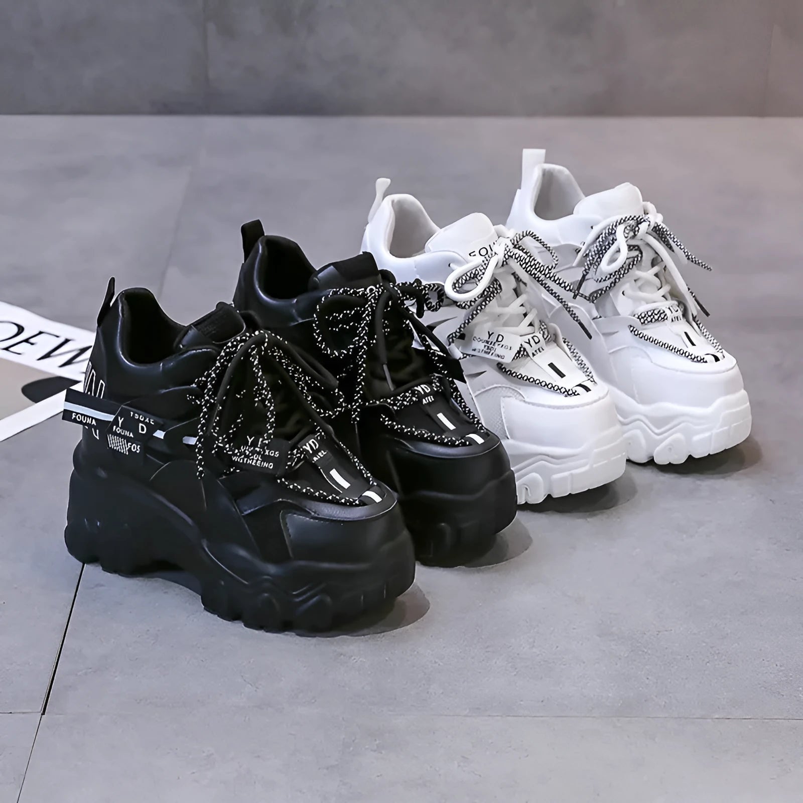 Women's white mesh platform trainers with cross-strap and chunky rubber sole on a neutral background.