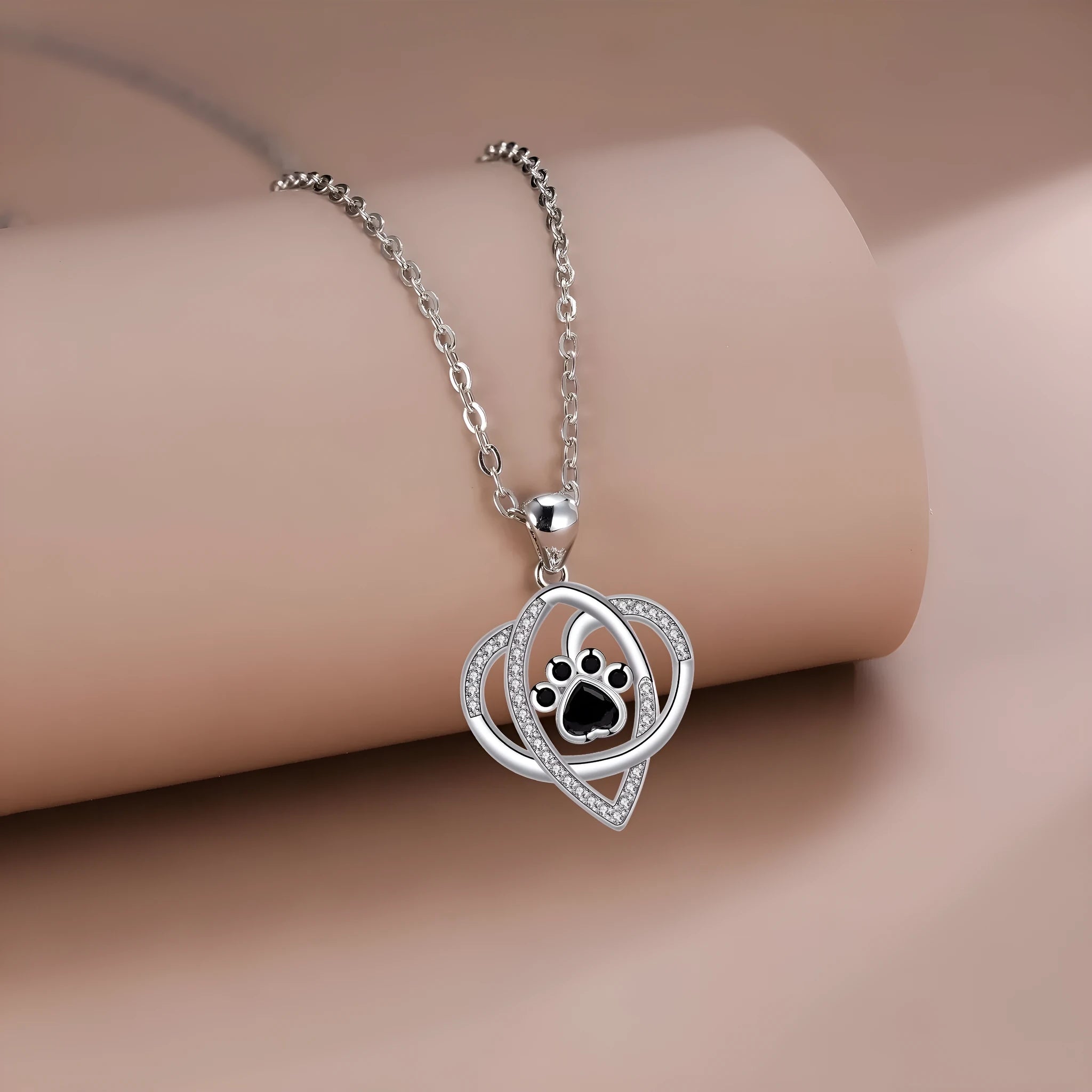 Copper necklace with cat and dog paw prints pendant on a cross chain, electroplated finish.
